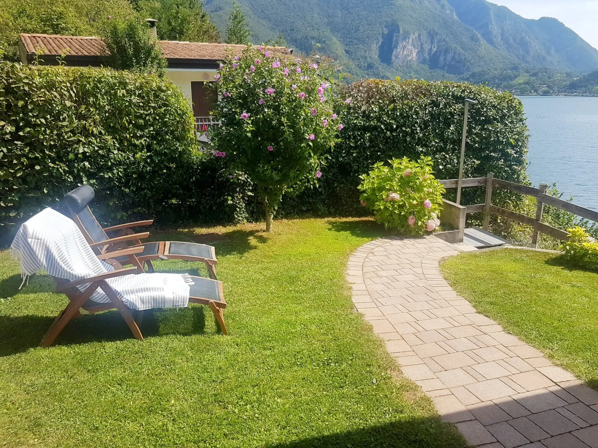 Garten der Villa Carina mit Liegestühlen und Blick auf den Ledrosee